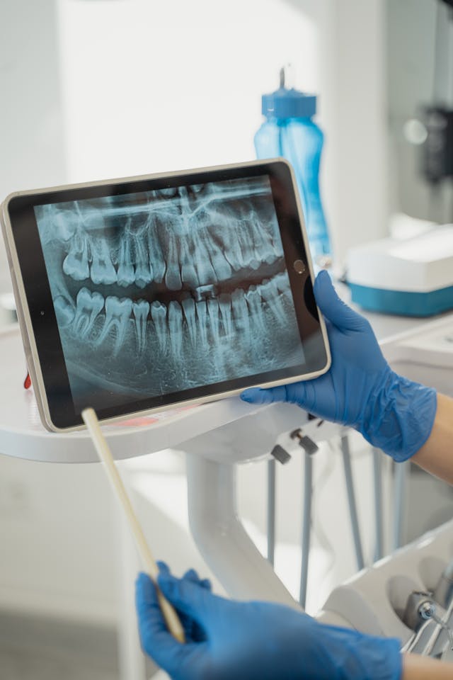 A person holding up an ipad with a picture of teeth.