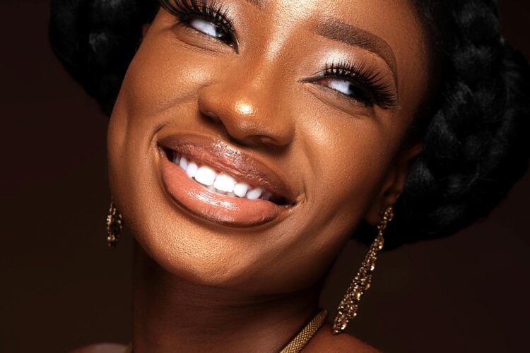 A woman with braids smiles for the camera.