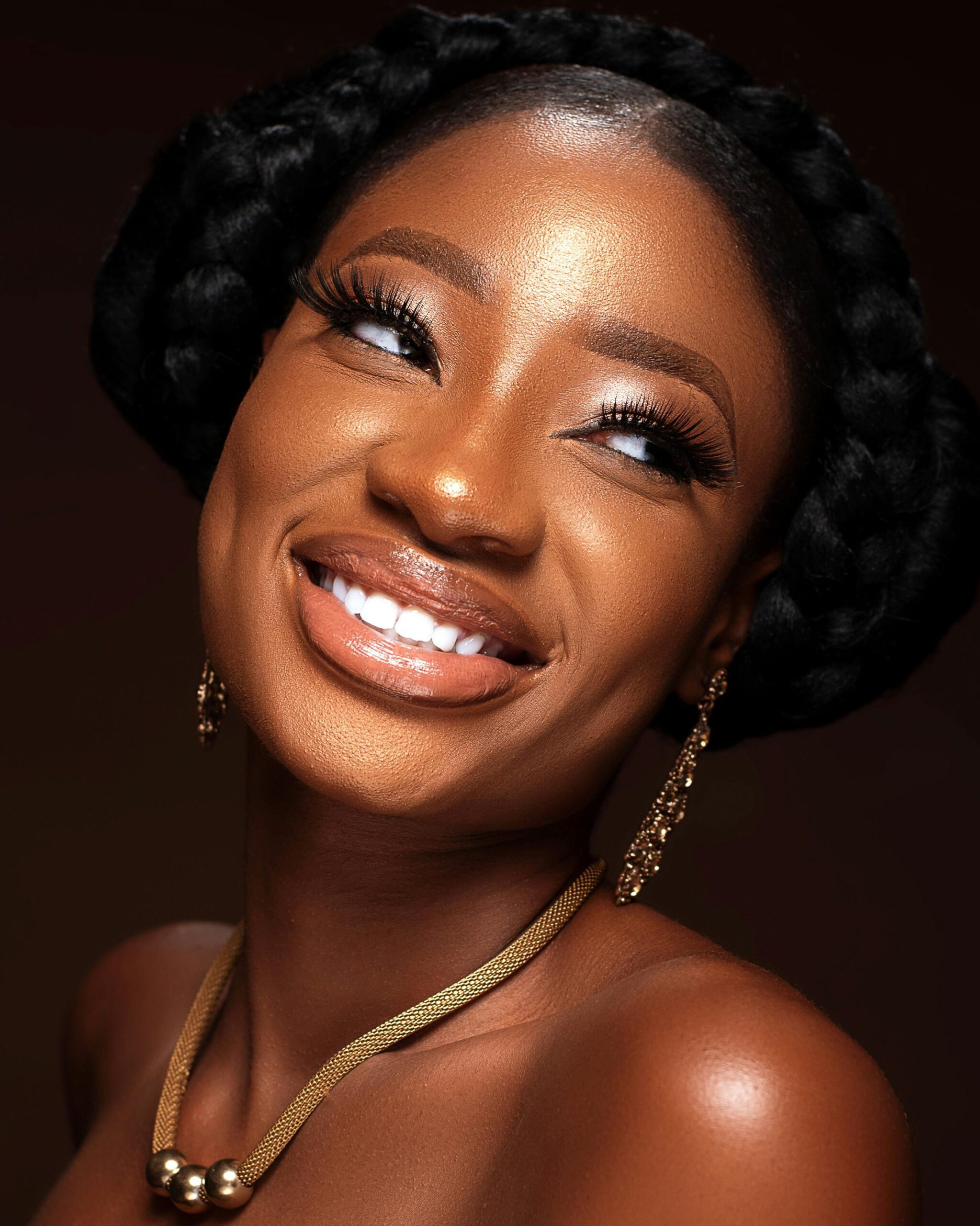 A woman with braids smiles for the camera.